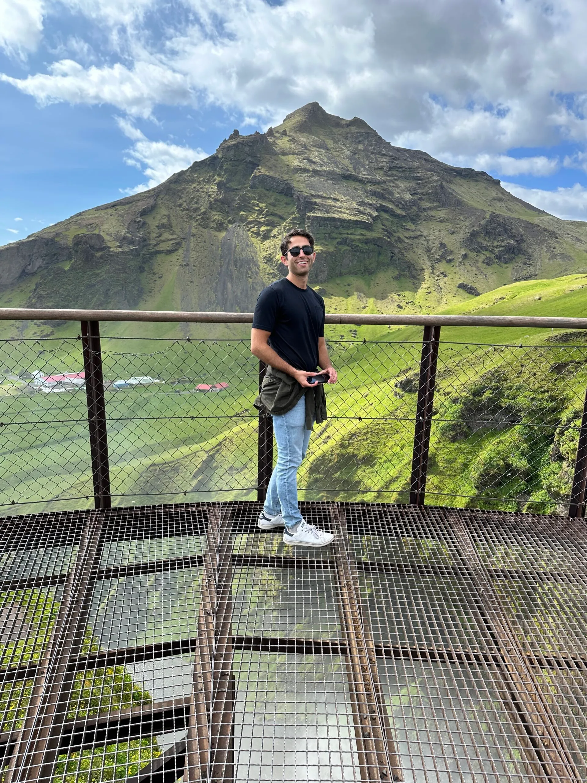 Author of Unrivaled 7-Day summer Iceland Itinerary standing in front of mountain located at Skogafoss
